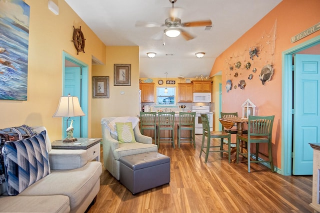 living room with wood-type flooring, vaulted ceiling, and ceiling fan