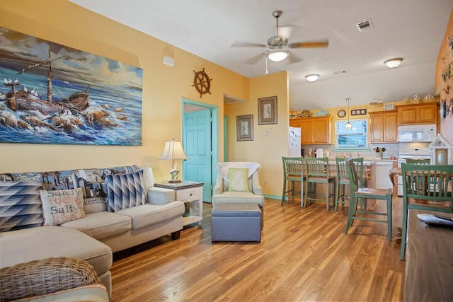 living room with ceiling fan and light wood-type flooring