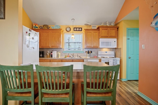 kitchen featuring lofted ceiling, sink, backsplash, hanging light fixtures, and white appliances