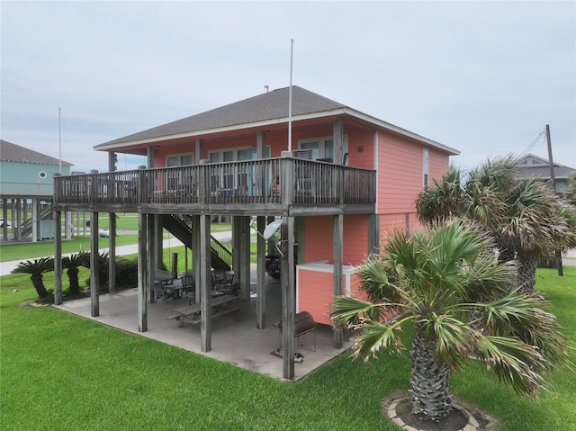 rear view of property with a wooden deck, a yard, and a patio area