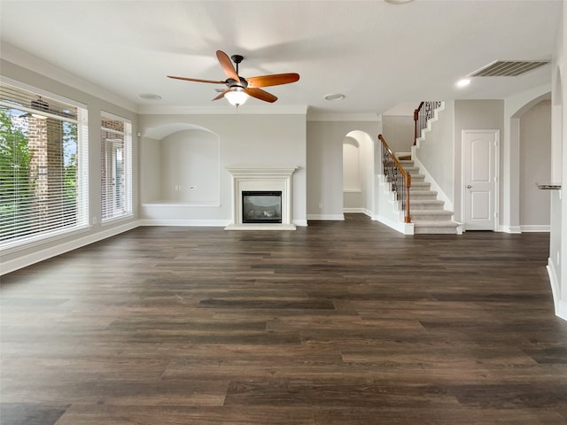 unfurnished living room with crown molding, ceiling fan, and dark hardwood / wood-style floors