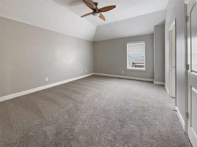 empty room with lofted ceiling, ceiling fan, and carpet flooring