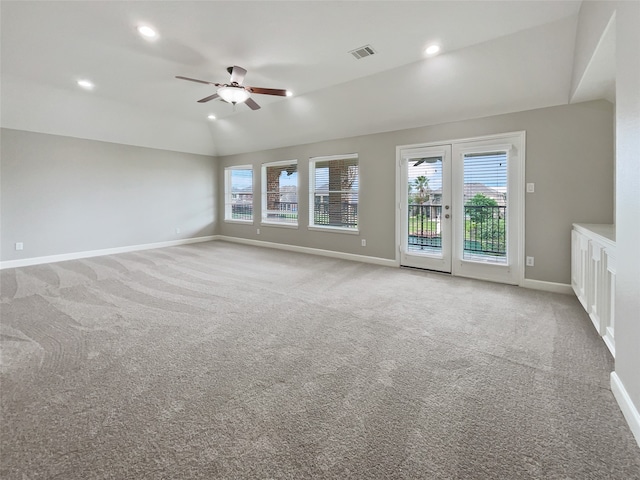 spare room featuring ceiling fan, light colored carpet, and vaulted ceiling