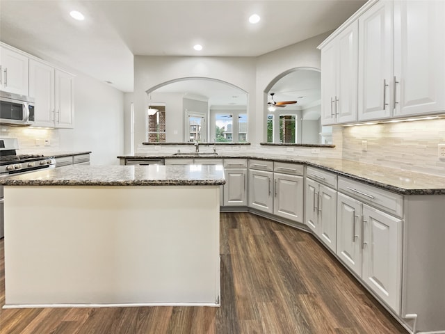 kitchen with appliances with stainless steel finishes, white cabinetry, and ceiling fan