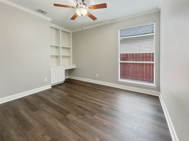 empty room with built in features, crown molding, ceiling fan, and dark hardwood / wood-style floors