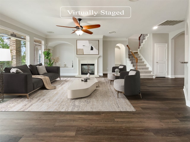 living room featuring crown molding, dark wood-type flooring, and ceiling fan