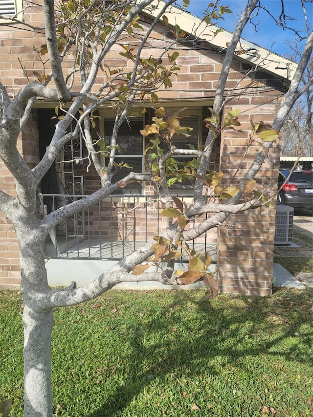 view of property exterior with a lawn and central air condition unit