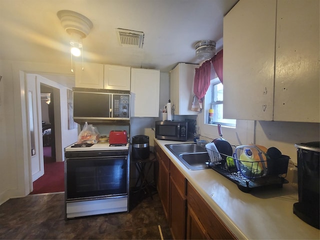 kitchen with white cabinets, white range, and sink