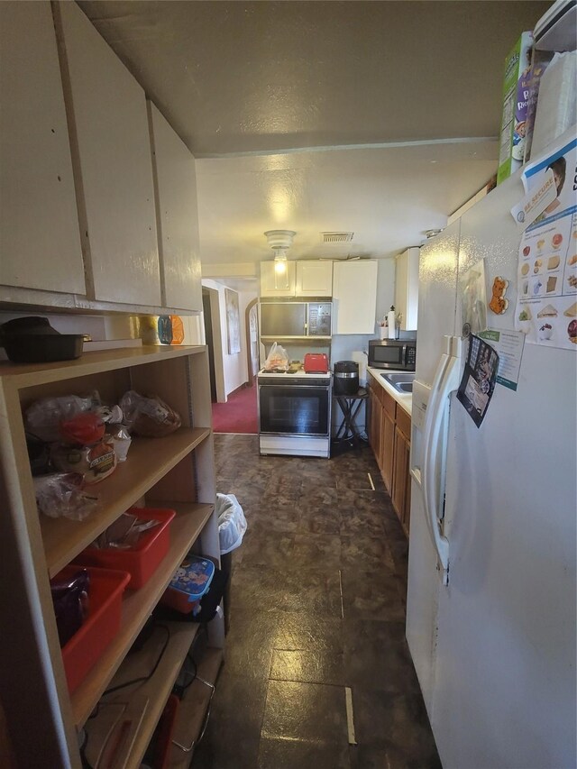 kitchen with white cabinetry and white appliances