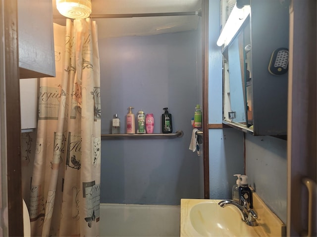 bathroom featuring shower / tub combo with curtain and sink