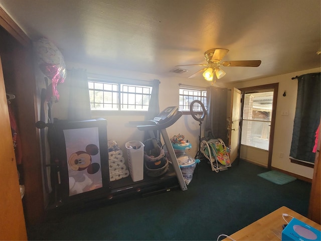 recreation room with ceiling fan and dark carpet