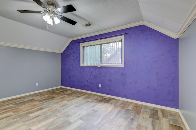 additional living space featuring ceiling fan, lofted ceiling, hardwood / wood-style floors, and a textured ceiling