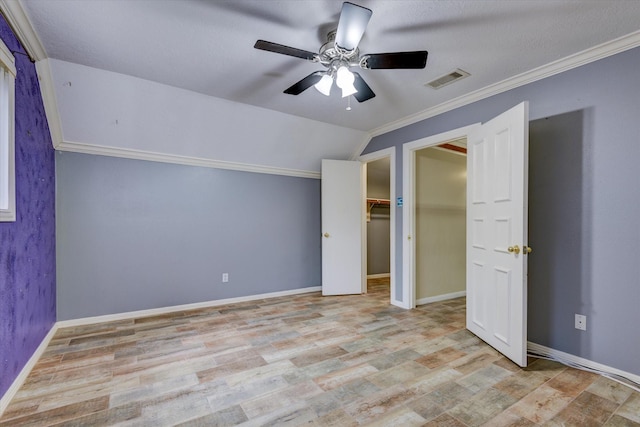 unfurnished bedroom featuring lofted ceiling, ornamental molding, light hardwood / wood-style floors, and ceiling fan