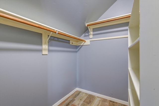 walk in closet featuring vaulted ceiling and hardwood / wood-style floors