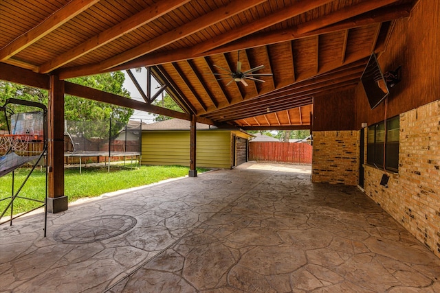 view of patio / terrace with a trampoline, ceiling fan, and a storage unit