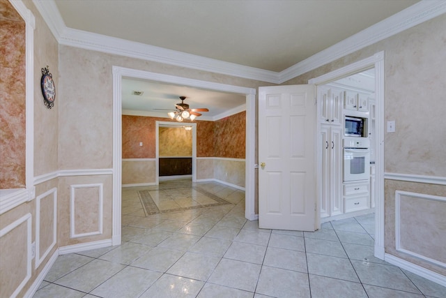 spare room featuring ornamental molding, light tile patterned floors, and ceiling fan