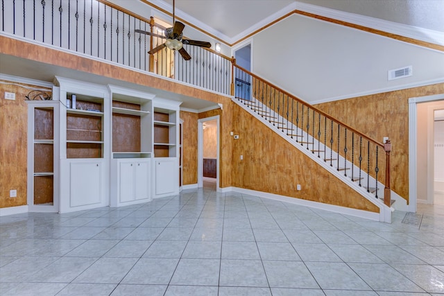 unfurnished living room with crown molding and wooden walls