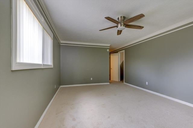 carpeted spare room featuring ornamental molding and ceiling fan