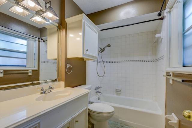 full bathroom featuring vanity, tiled shower / bath, and toilet