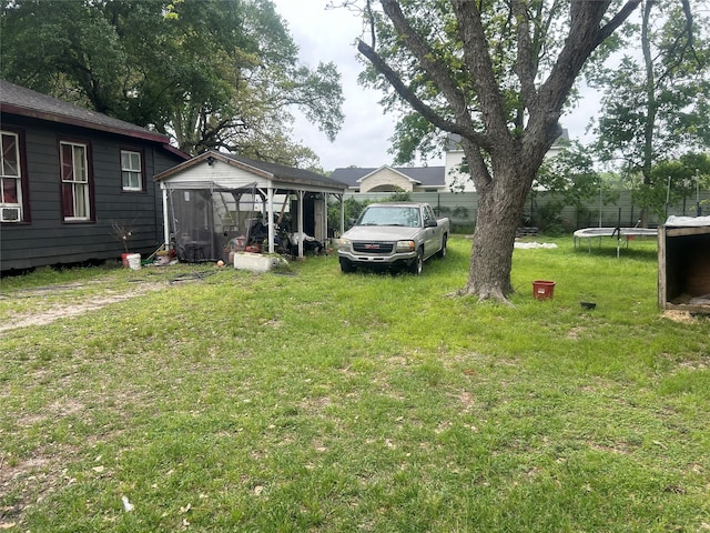 view of yard with a sunroom and a trampoline