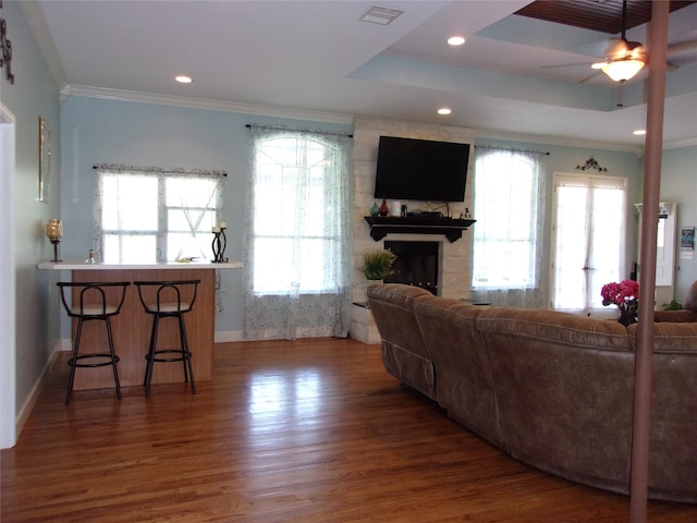 living room with ceiling fan, a healthy amount of sunlight, a fireplace, and dark wood-type flooring