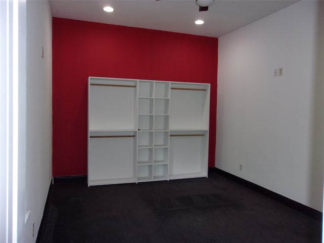 unfurnished bedroom with a closet and dark colored carpet