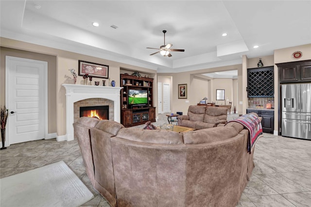 living room featuring a tray ceiling and ceiling fan