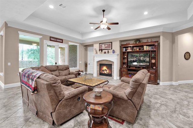 living room with french doors, a raised ceiling, ceiling fan, and crown molding