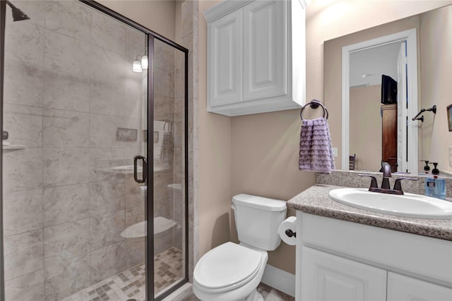 bathroom featuring vanity, toilet, and an enclosed shower