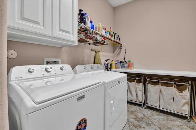 clothes washing area with cabinets, light tile patterned floors, and washer and clothes dryer