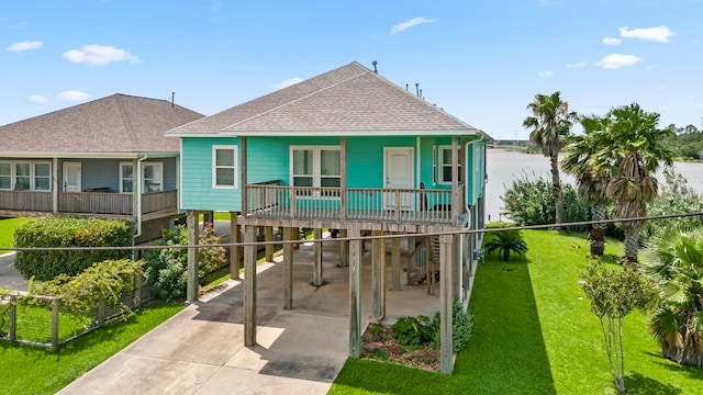 exterior space featuring covered porch, a carport, and a lawn