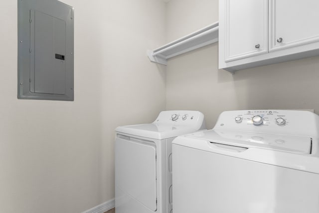 laundry room featuring cabinets, washing machine and dryer, and electric panel