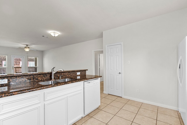 kitchen with white appliances, ceiling fan, sink, dark stone countertops, and white cabinetry