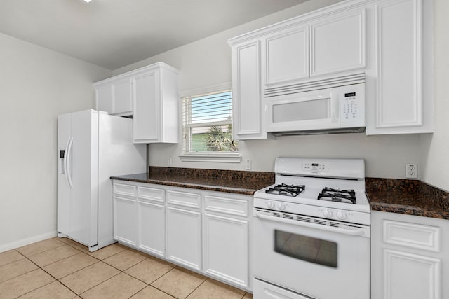 kitchen featuring white cabinetry, dark stone countertops, white appliances, and light tile patterned floors