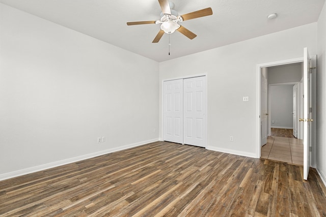 unfurnished bedroom featuring ceiling fan, dark wood-type flooring, and a closet