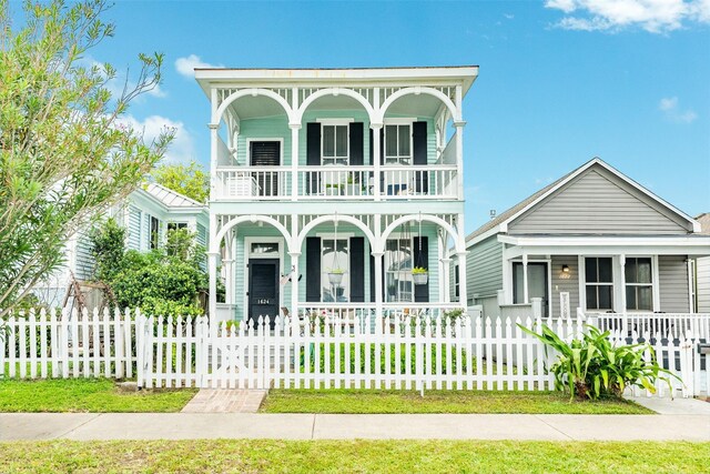 view of front of house with a balcony, a front lawn, and a porch