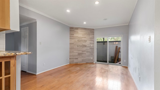 unfurnished room featuring light hardwood / wood-style floors and crown molding