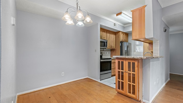 kitchen with light hardwood / wood-style floors, light stone countertops, appliances with stainless steel finishes, decorative light fixtures, and a chandelier