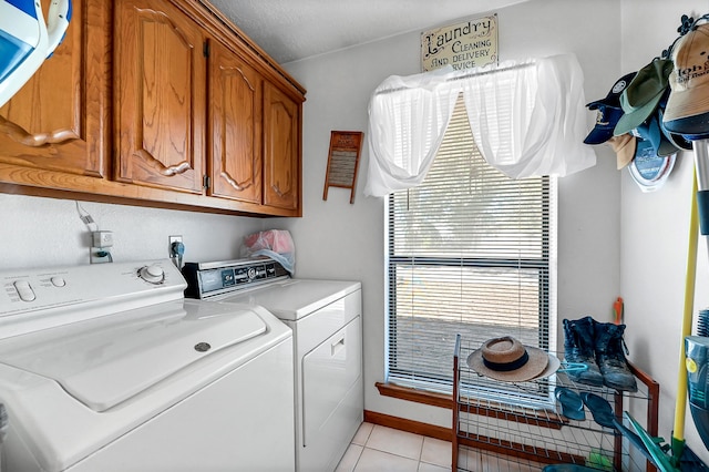 laundry room featuring separate washer and dryer, a healthy amount of sunlight, cabinets, and light tile floors