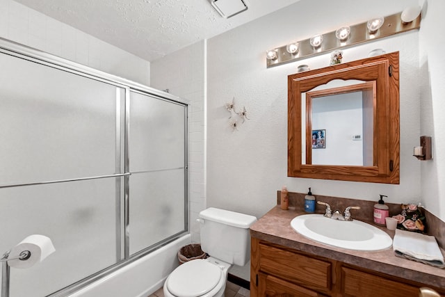 full bathroom with a textured ceiling, vanity, toilet, and bath / shower combo with glass door