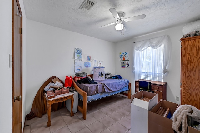 tiled bedroom with a textured ceiling and ceiling fan