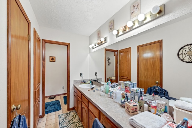 bathroom with tile flooring, a textured ceiling, and vanity