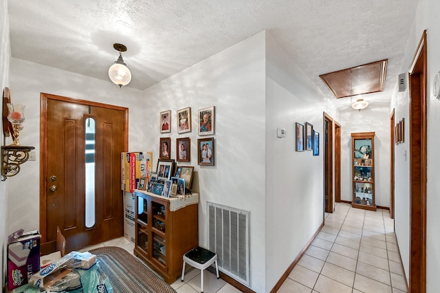 entryway featuring a textured ceiling and light tile flooring