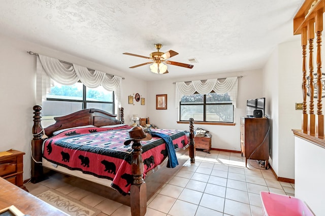 tiled bedroom featuring ceiling fan and a textured ceiling