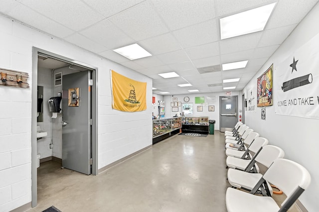 interior space featuring concrete flooring and a drop ceiling