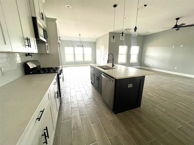 kitchen featuring appliances with stainless steel finishes, sink, an island with sink, and white cabinets