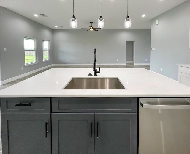 kitchen featuring light countertops, visible vents, stainless steel dishwasher, open floor plan, and a sink