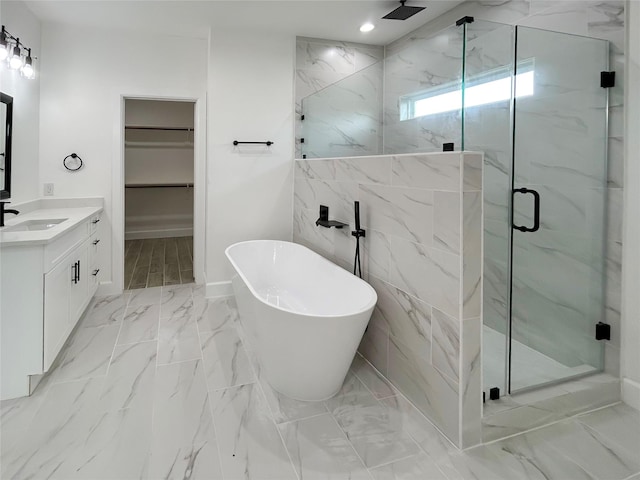 full bathroom featuring a marble finish shower, a soaking tub, marble finish floor, a spacious closet, and vanity