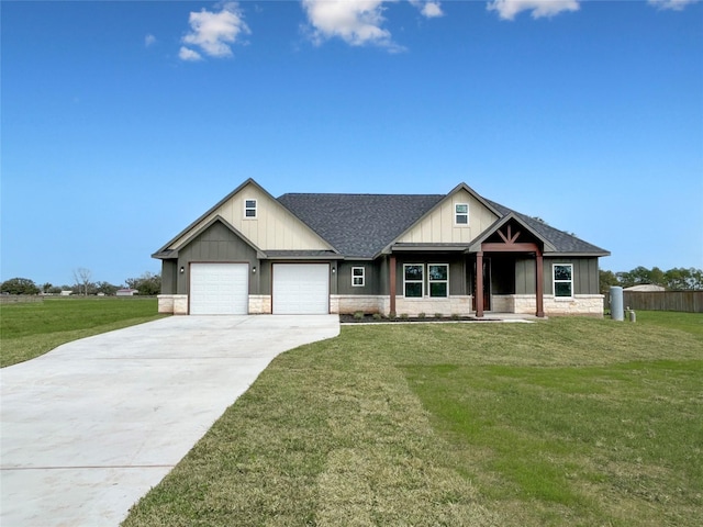 view of front of home featuring stone siding, a front lawn, and an attached garage