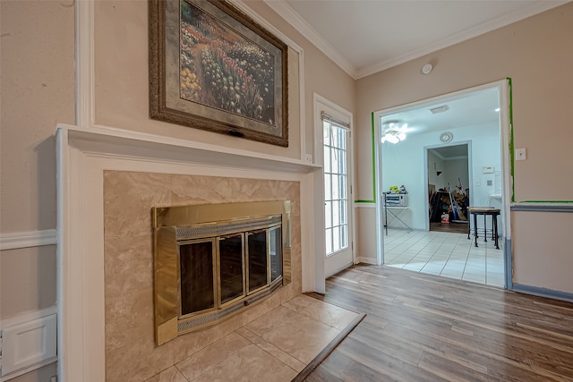 living room with wood-type flooring, a fireplace, and ornamental molding